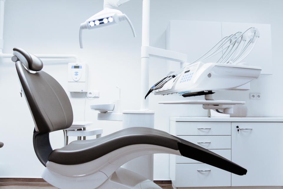 A dental treatment room with chair and instrument tray